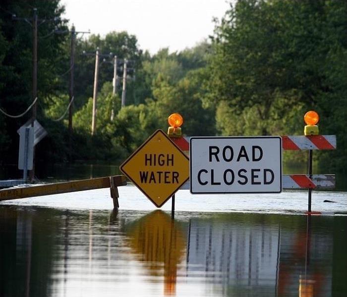 Road closed sign across flooded road